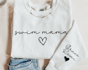 May include: White sweatshirt with the text "swim mama" and a heart on the front. The left sleeve has the text "Grace Remi" and a heart.