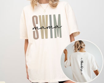 May include: Ivory oversized t-shirt with the text "swim mama" in colorful block letters on the front and the text "theodore" on the back.
