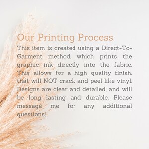 Peut inclure: Texte expliquant le processus d'impression Direct-To-Garment. Le texte dit : "Cet article est cr&eacute;&eacute; &agrave; l'aide d'une m&eacute;thode d'impression Direct-To-Garment, qui imprime l'encre graphique directement dans le tissu. Cela permet d'obtenir une finition de haute qualit&eacute;, qui ne craquera pas et ne se d&eacute;collera pas comme le vinyle. Les motifs sont clairs et d&eacute;taill&eacute;s, et seront durables. N'h&eacute;sitez pas &agrave; me contacter pour toute question suppl&eacute;mentaire !"