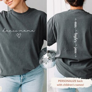 K&ouml;nnte beinhalten: Ein dunkelgraues T-Shirt mit dem Text "dance mama" und einem Herz auf der Vorderseite. Auf der R&uuml;ckseite des Shirts steht der Text "max taylor jane" vertikal auf dem R&uuml;cken.