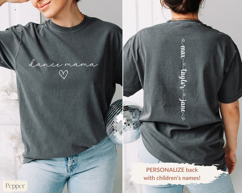 K&ouml;nnte beinhalten: Ein dunkelgraues T-Shirt mit dem Text "dance mama" und einem Herz auf der Vorderseite. Auf der R&uuml;ckseite des Shirts steht der Text "max taylor jane" vertikal auf dem R&uuml;cken.