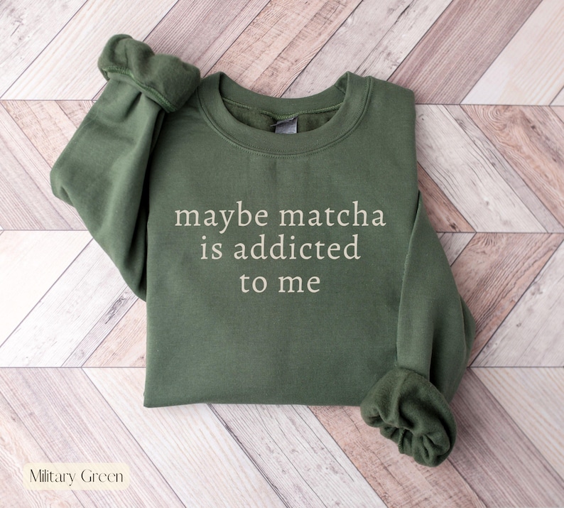 Puede incluir: Sudadera verde militar con el texto blanco "maybe matcha is addicted to me". La parte superior de manga larga est&aacute; hecha de un material suave y tiene cuello redondo.