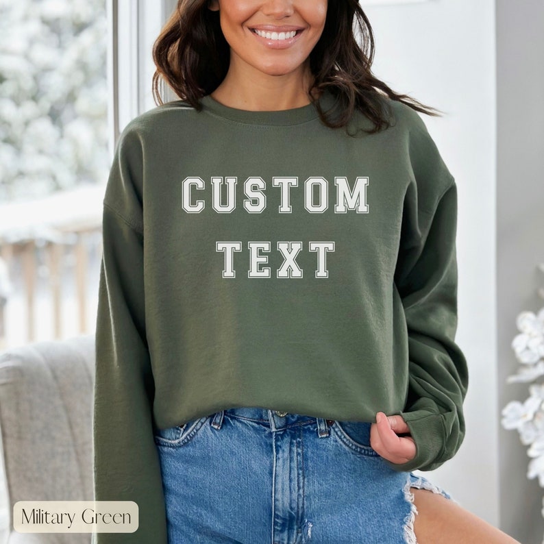 Peut inclure: Un sweat-shirt vert avec le texte "CUSTOM TEXT" en lettres blanches. Le sweat-shirt est fait d'un mat&eacute;riau doux et confortable et a une coupe d&eacute;contract&eacute;e.