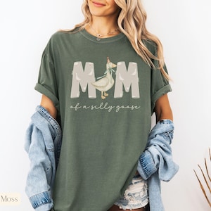 Puede incluir: Una camiseta verde con un gr&aacute;fico blanco de un ganso con un gorro de fiesta y el texto "Mom of a silly goose".