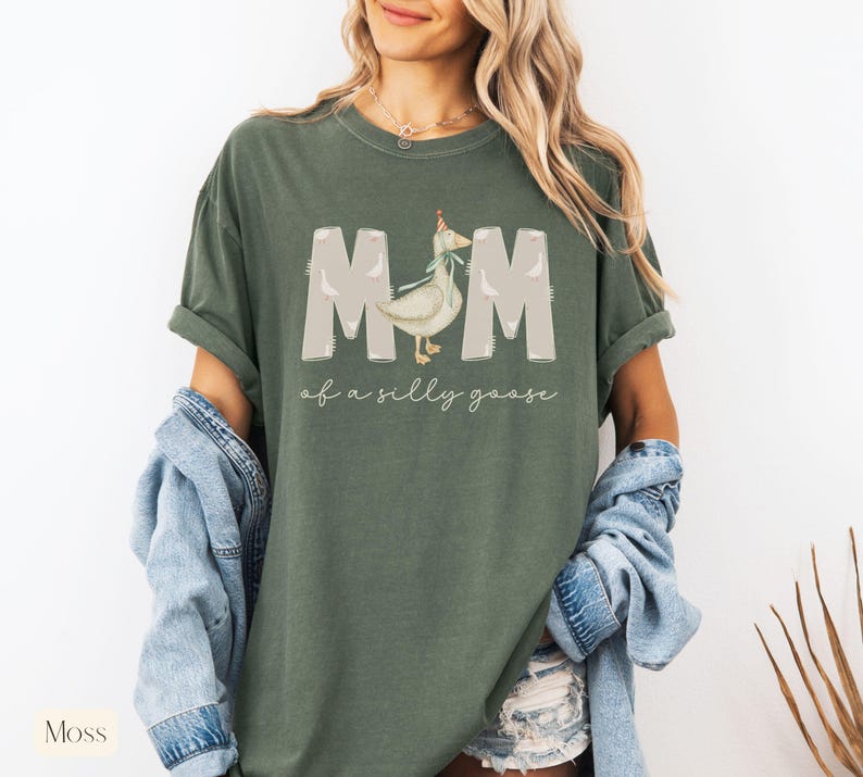 Puede incluir: Una camiseta verde con un gr&aacute;fico blanco de un ganso con un gorro de fiesta y el texto "Mom of a silly goose".