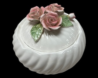 Puede incluir: Caja de cerámica blanca con tapa decorada con tres rosas rosas y hojas verdes.