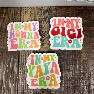 May include: Three white stickers with colorful text that reads "In My Nonna Era", "In My Gigi Era", and "In My Yaya Era".