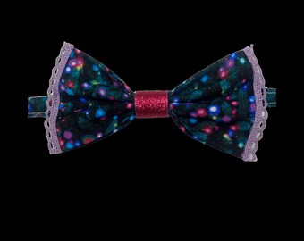 Christmas light sparkle, pet bow tie, Christmas tree branches with pink, purple & blue lights. With a sparkly pink center and purple trim.