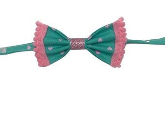 Sweet Hearts, pet bow tie, turquoise with pink hearts and pink pompom trim, with a sparkly pink center.