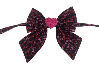 Love, hugs and kisses, pet sailors bow tie, black with pink and red writing. With sparkly heart decal center.