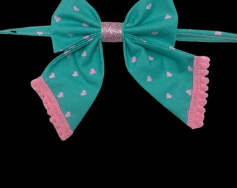 Sweet Hearts, pet sailors bow tie, turquoise with pink hearts and pink pompom trim, with a sparkly pink center.