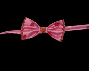 The Romantic, pet bow tie, pink satin with red and pink hearts. With metallic red ricrac trim and sparkly red heart decal center.