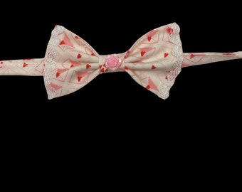 Love Letters, pet bow tie, white with pink love letters. With white metallic ricrac trim and rose gem center.