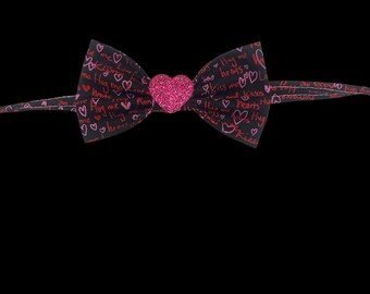 Love, hugs and kisses, pet bow tie, black with pink and red writing. With sparkly heart decal center.