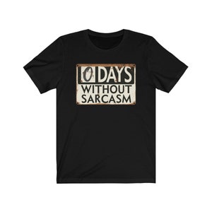 May include: Black t-shirt with a white sign that says "0 DAYS WITHOUT SARCASM". The sign is designed to look like a vintage metal sign with rust and wear.