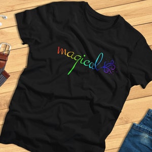 May include: Black t-shirt with a rainbow-colored "magical" design and a stylized swirl.