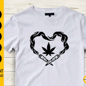 May include: White t-shirt featuring a black heart-shaped design with a cannabis leaf in the center. The heart is formed by smoke and two joints. The words "INSTANT DOWNLOAD" are also visible.