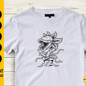 May include: White t-shirt featuring a black and white illustration of a carnivorous plant with sharp teeth and a long tongue. The shirt has the words "SVG, DXF, PNG, EPS, AI" and "INSTANT DOWNLOAD" in a yellow and black vertical column on the left side.