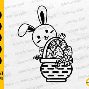 Puede incluir: Gráfico de Pascua en blanco y negro con un conejito mirando por encima de una cesta llena de huevos decorados y flores. Incluye el texto "DESCARGA INSTANTÁNEA".