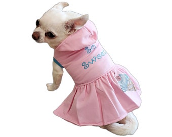 Peut inclure: Un petit chien blanc portant une robe rose à capuche avec un cône de glace brodé en bleu et le texte "So Sweet" sur le devant.