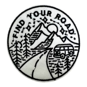 Op de afbeelding: Zwart-witte geborduurde patch met een berglandschap, een busje en de tekst "FIND YOUR ROAD".
