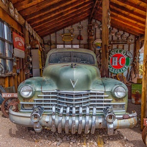 Old Green Cadillac with chrome bumper in a old wooden garage setting