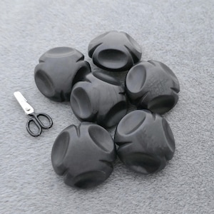 May include: A white ceramic mug with a black handle and the text "But First, Coffee" in a black, handwritten-style font. The mug is on a white surface.