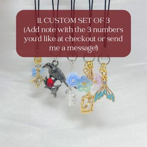 May include: A set of five hanging charms on black cords, including a gold star, a black raven with a red stone, a blue flower, a gold frame, and a blue mermaid tail. Text reads: 11. CUSTOM SET OF 3 (Add note with the 3 numbers you'd like at checkout or send me a message!)