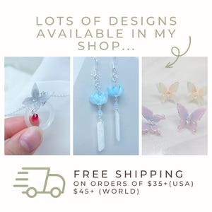 May include: Image showcasing various jewelry designs. Featured are a silver necklace with a butterfly pendant and a red gem, blue flower earrings, and butterfly stud earrings. The text reads "LOTS OF DESIGNS AVAILABLE IN MY SHOP..."