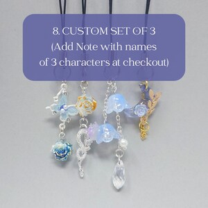 K&ouml;nnte beinhalten: Ein Set aus drei individuell gestalteten Charms mit verschiedenen dekorativen Elementen, darunter ein Schmetterling, eine Rose und florale Designs. Die Charms sind an schwarzen Kordeln befestigt. Text auf dem Bild: "8. CUSTOM SET OF 3 (Add Note with names of 3 characters at checkout)".