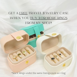 May include: Three small travel jewelry cases in pink, white, and teal, each with gold hardware. The cases are open, displaying rings with various gemstones. Text reads: "GET A FREE TRAVEL JEWELRY CASE WHEN YOU BUY 3 OR MORE RINGS FROM MY SHOP!" and "Stack Rings under the same listing count as 1 ring."