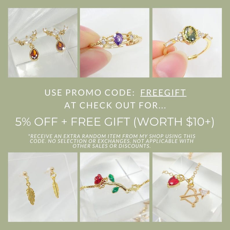 May include: A collage of gold-toned jewelry, including earrings with amber-colored teardrop pendants, rings with purple and green gemstones, a bracelet with a red rose, and a necklace with a heart and bow and arrow charm. Text reads: USE PROMO CODE: FREEGIFT.
