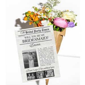 Puede incluir: Una tarjeta con estilo de periódico con una foto en blanco y negro de dos mujeres y el texto "The Bridal Party Times" y "Will you be my bridesmaid?" La tarjeta está rodeada de un ramo de flores.