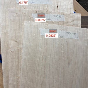 May include: Three pieces of wood veneer, each with a different thickness. The top piece is 0.175 inches thick, the middle piece is 0.0375 inches thick, and the bottom piece is 0.0825 inches thick. Each piece is 7.5 inches by 23.5 inches.