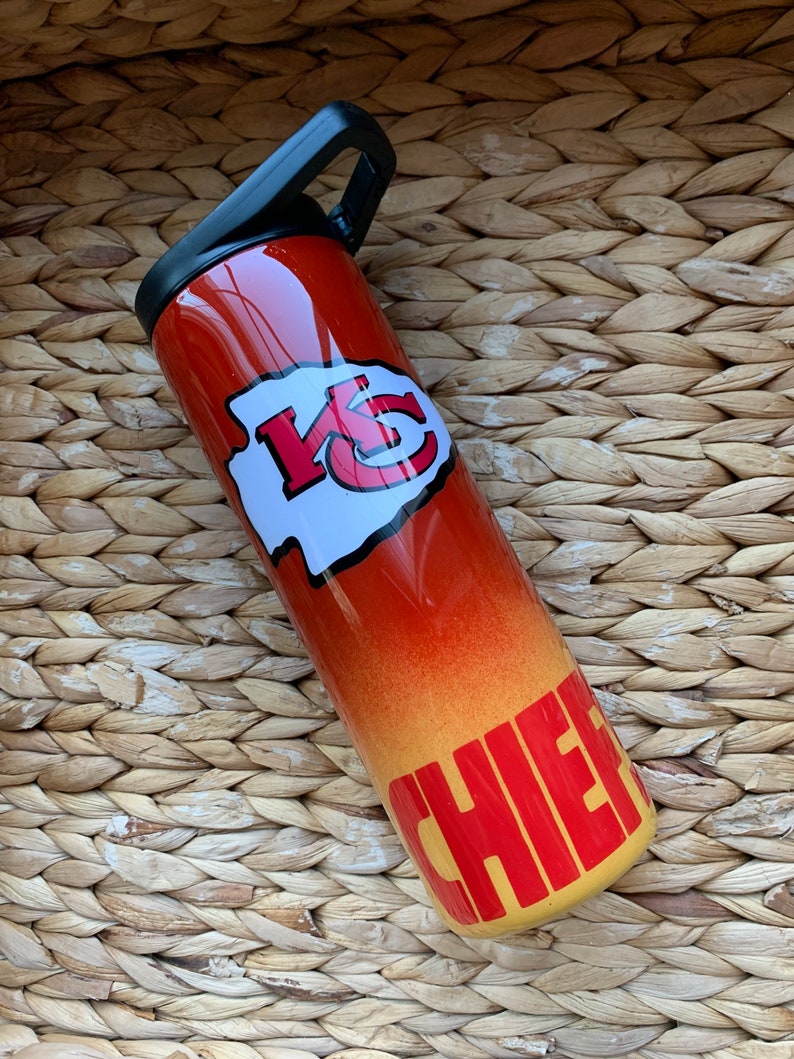 May include: A red and yellow stainless steel water bottle with a Kansas City Chiefs logo and the word "Chiefs" in yellow letters.