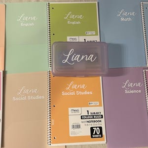 May include: A collection of spiral notebooks and a pencil case, all with the name "Liana" in cursive. The notebooks are in various pastel colors, including pink, peach, green, and blue. Each notebook is college ruled and contains 70 sheets.