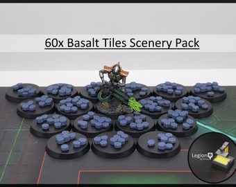 Op de afbeelding: Een 60x Basalt Tiles Scenery Pack met kleine, grijze, zeshoekige tegels op ronde zwarte basissen. Een metalen zilveren en bronzen miniatuurfiguur met een groen gloeiend wapen staat tussen de tegels. De tekst 60x Basalt Tiles Scenery Pack is zichtbaar.