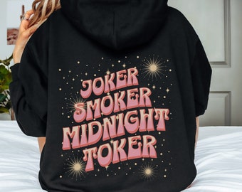 May include: Black hoodie with a pink and white graphic print that says "Joker Smoker Midnight Toker" with gold stars and fireworks.