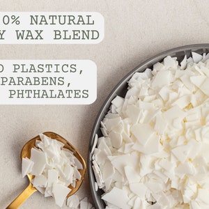 May include: Close-up of white soy wax flakes in a gray bowl and a gold spoon. The text "100% NATURAL SOY WAX BLEND" and "NO PLASTICS, PARABENS, OR PHTHALATES" is visible in the image.
