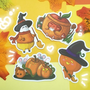 May include: Four colorful stickers featuring cute cartoon characters. The stickers are shaped like pumpkins, a witch, and a squirrel. The stickers are perfect for adding a touch of whimsy to your planner, laptop, or water bottle.