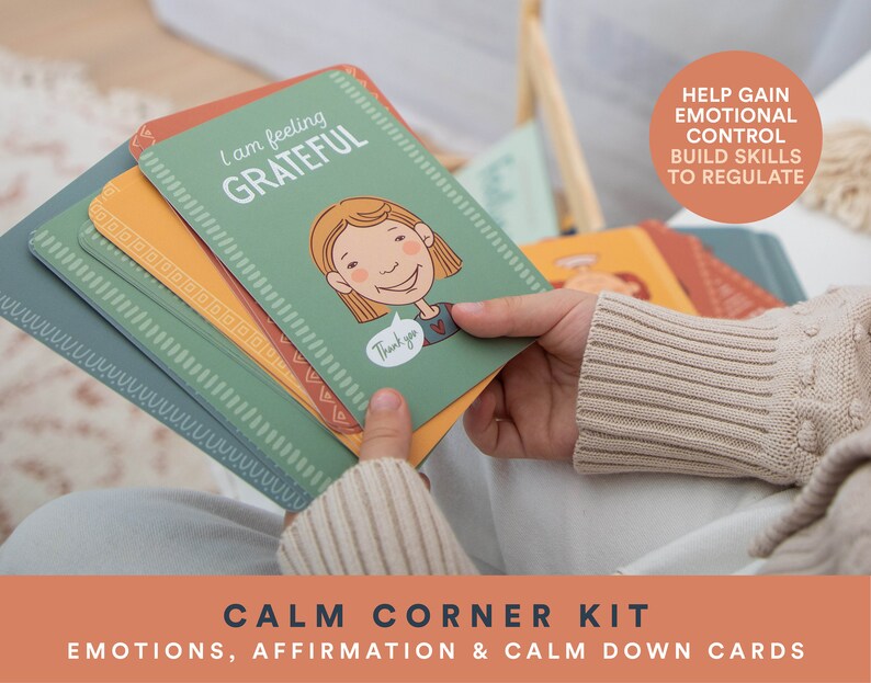 K&ouml;nnte beinhalten: Ein Satz bunter Karten mit Illustrationen und Text. Die Karten sind mit "Calm Corner Kit" und "Emotions, Affirmation & Calm Down Cards" beschriftet. Eine Karte lautet "Ich bin dankbar" und zeigt ein Cartoon-M&auml;dchen mit einem gl&uuml;cklichen Gesichtsausdruck. Der Text "Hilft, emotionale Kontrolle zu gewinnen, F&auml;higkeiten zum Regulieren aufzubauen" ist im Hintergrund sichtbar.