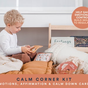 K&ouml;nnte beinhalten: Ein Kind sitzt auf einer braunen und wei&szlig;en Decke und betrachtet ein Kartenset mit Illustrationen von Tieren und Emotionen. Die Karten sind Teil eines "Calm Corner Kit", das Emotionen-, Affirmations- und Beruhigungskarten enth&auml;lt. Das Kit soll Kindern helfen, emotionale Kontrolle zu erlangen, F&auml;higkeiten aufzubauen und ihre Emotionen zu regulieren.