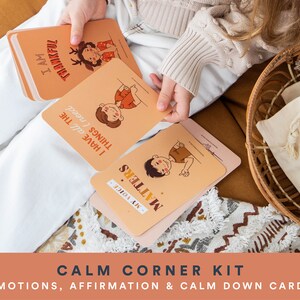 K&ouml;nnte beinhalten: Ein Satz bunter Karten mit Illustrationen und Affirmationen f&uuml;r Kinder. Die Karten zeigen S&auml;tze wie "Ich bin dankbar" und "Meine Stimme z&auml;hlt". Die Karten befinden sich in einem Korb mit einer wei&szlig;en Stofftasche.