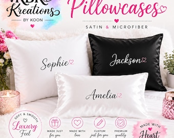 Pode incluir: Três fronhas retangulares de cetim branco e preto, cada uma personalizada com um nome em escrita preta e um pequeno ícone de coração rosa. O texto diz KBK Kreations by Koon, Personalized Pillowcases, Satin & Microfiber, Made with Heart.
