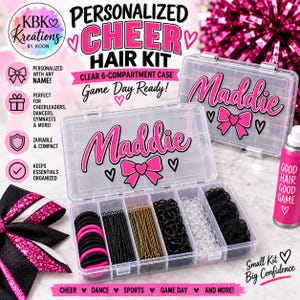 May include: A clear plastic 6-compartment storage case personalized with the name Maddie in pink and black text, featuring a pink bow graphic. The case contains black and pink hair ties, bobby pins, and hair nets, alongside a pink hair spray bottle.