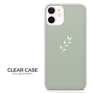 May include: A clear phone case with a sage green back and a white floral design. The case is designed for an iPhone with a camera bump.