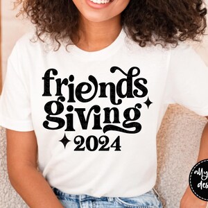 May include: White t-shirt with black text that reads "Friendsgiving 2024".