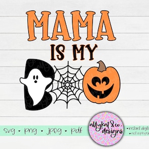 Peut inclure: Un design num&eacute;rique avec le texte "Mama is my Boo" avec un fant&ocirc;me, une citrouille et une toile d'araign&eacute;e. Le design est en noir, orange et blanc.