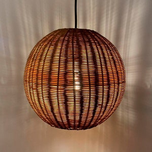 May include: A round, woven wicker pendant light fixture with a warm, glowing light emanating from inside.