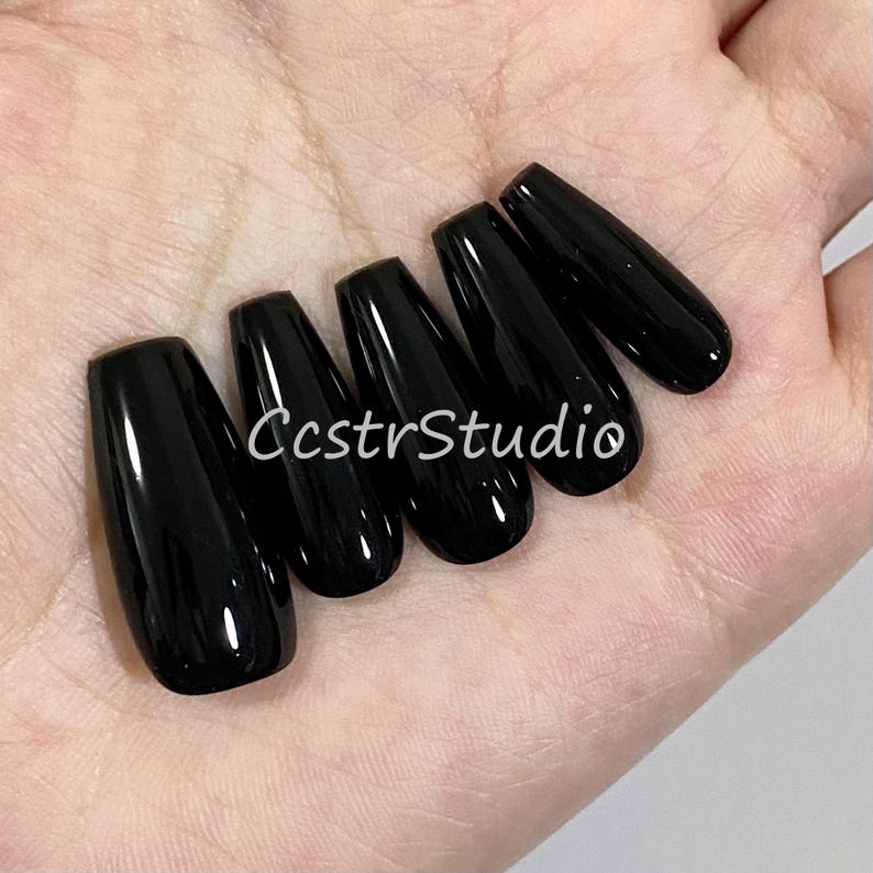 May include: Six black coffin-shaped false nails.